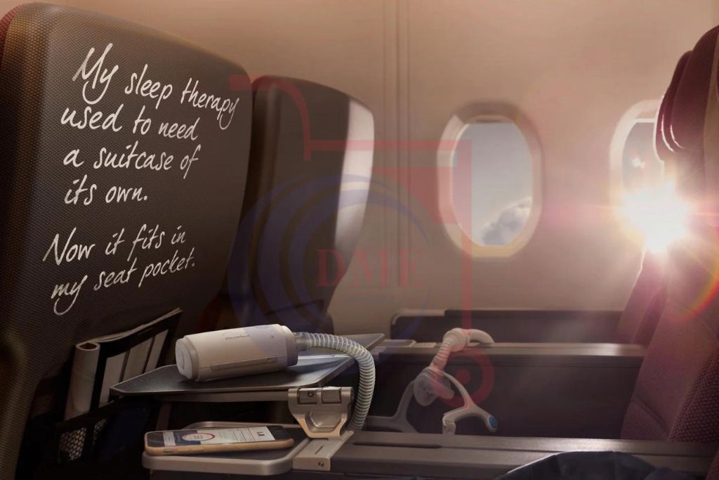 Resmed AirMini AutoSet Portable CPAP machine placed on airplane tray table next to phone